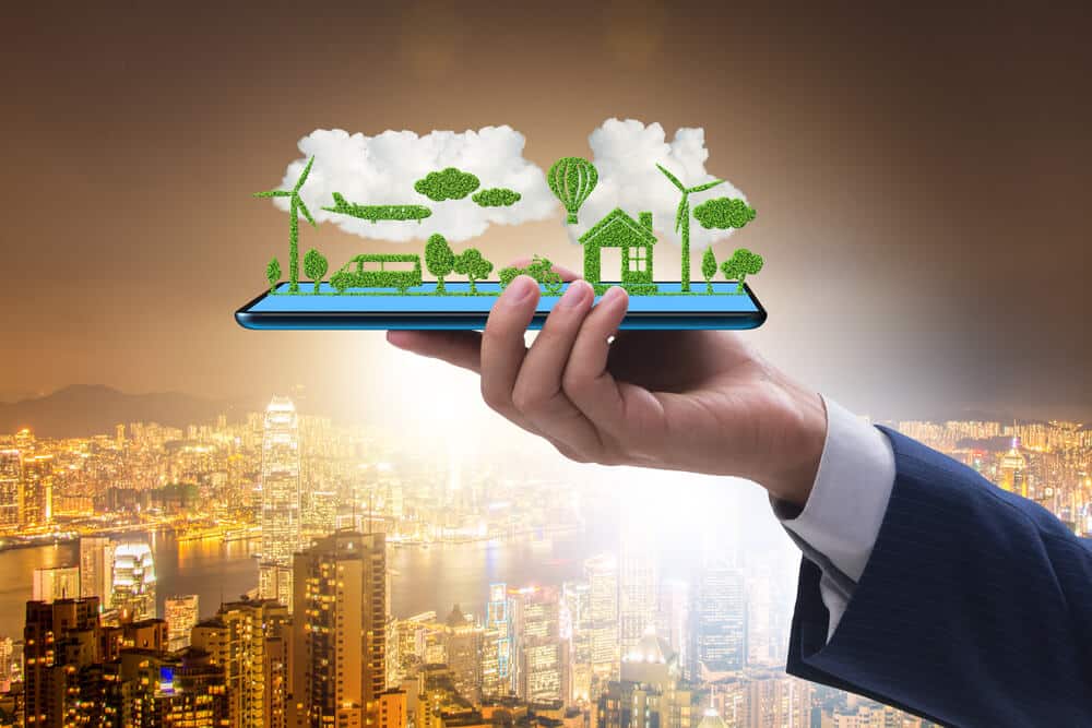 Hand holding tablet with mini ecosystem - Small Energy Bill